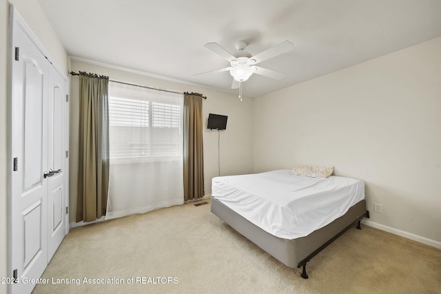 carpeted bedroom with ceiling fan and a closet