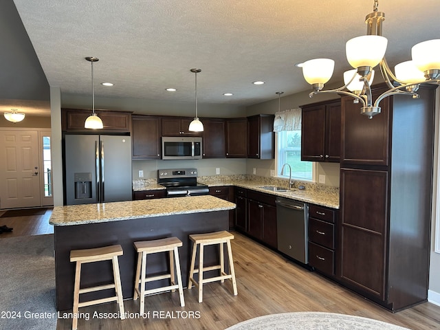 kitchen with a center island, light hardwood / wood-style flooring, and appliances with stainless steel finishes