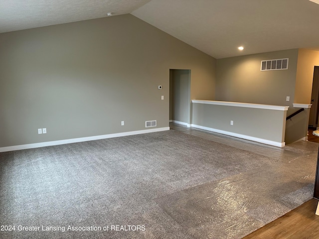 spare room featuring wood-type flooring, a textured ceiling, and vaulted ceiling