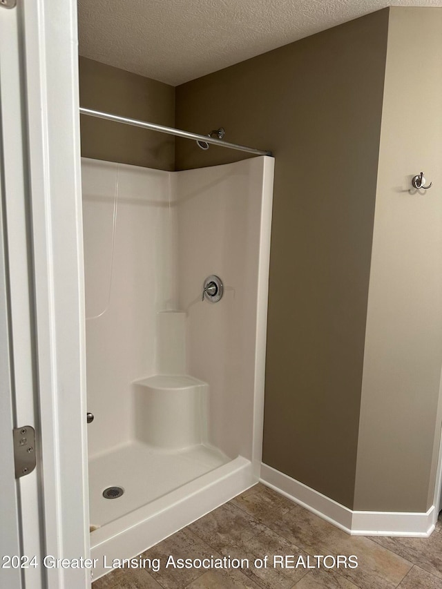 bathroom with a textured ceiling and walk in shower