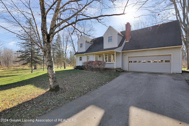 cape cod-style house featuring a garage and a front yard