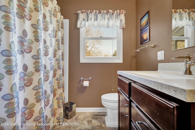 bathroom featuring curtained shower, vanity, and toilet