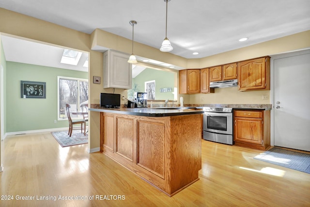 kitchen with kitchen peninsula, a skylight, light hardwood / wood-style floors, hanging light fixtures, and stainless steel electric range