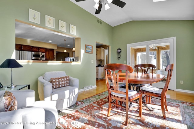 dining space with light hardwood / wood-style floors, vaulted ceiling, and ceiling fan