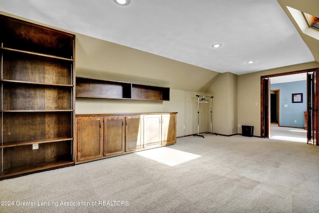 unfurnished living room with light carpet and a skylight