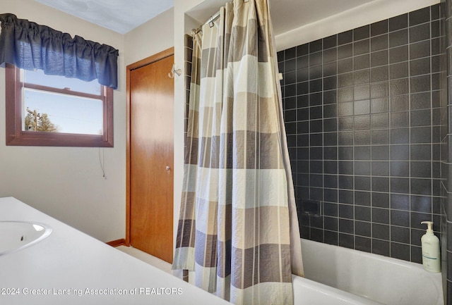 bathroom with shower / tub combo with curtain and sink