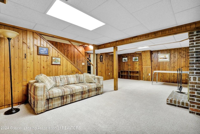 carpeted living room with a paneled ceiling and wooden walls