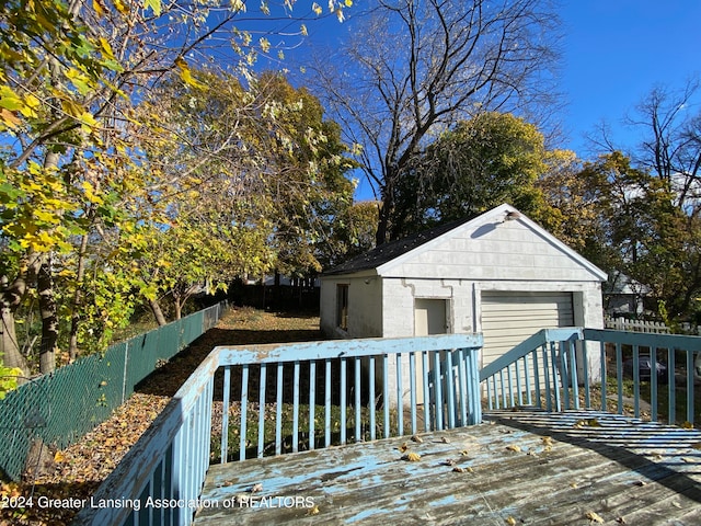 wooden terrace featuring an outbuilding and a garage