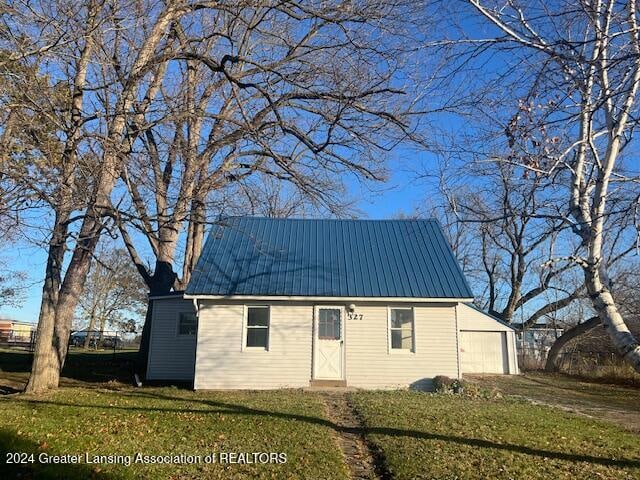 view of front of house with an outbuilding, a garage, and a front yard