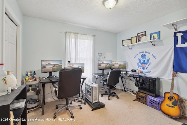 carpeted home office featuring a textured ceiling