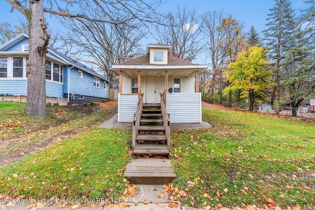 bungalow-style house featuring covered porch and a front yard