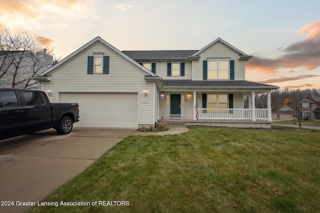 view of front of property featuring a yard, covered porch, and a garage