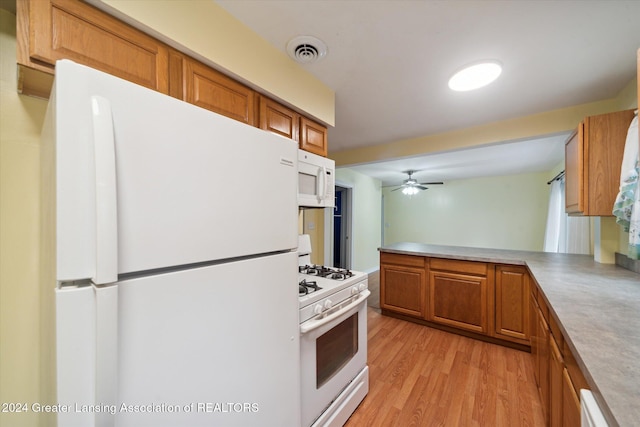 kitchen with ceiling fan, light wood-type flooring, white appliances, and kitchen peninsula