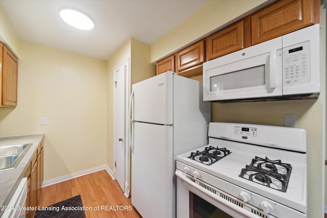 kitchen featuring light hardwood / wood-style floors, white appliances, and sink