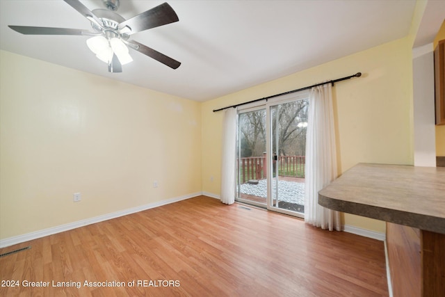 empty room with hardwood / wood-style floors and ceiling fan