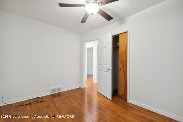 unfurnished bedroom featuring hardwood / wood-style floors, ceiling fan, and a closet