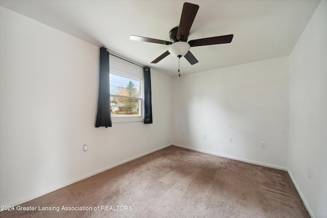 carpeted spare room featuring ceiling fan