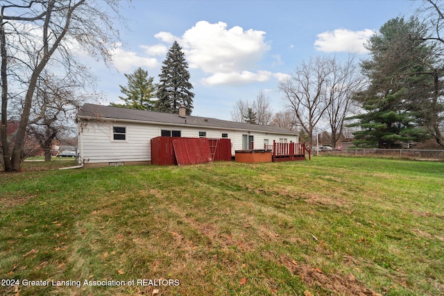 back of house with a deck and a yard