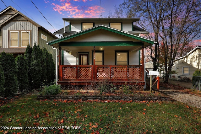 view of front of house with a lawn and a porch