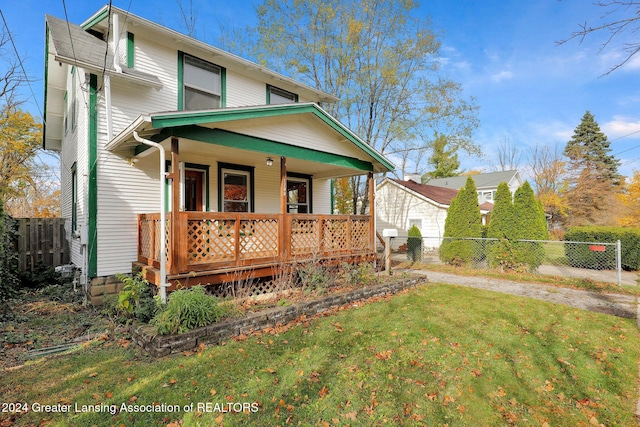 back of house featuring a lawn and a porch