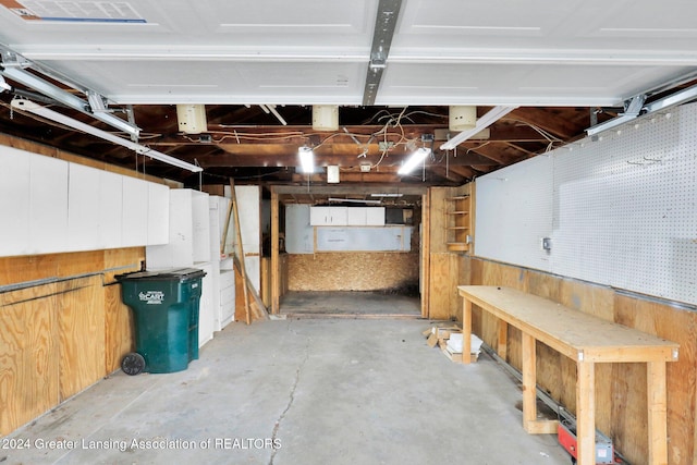 basement with a workshop area and wooden walls