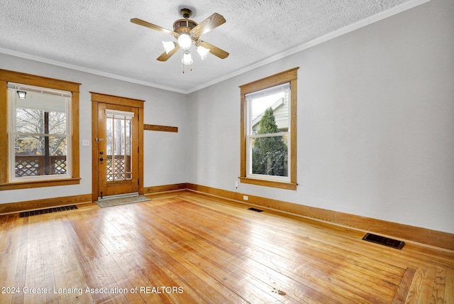 unfurnished room with a textured ceiling, hardwood / wood-style flooring, ceiling fan, and ornamental molding