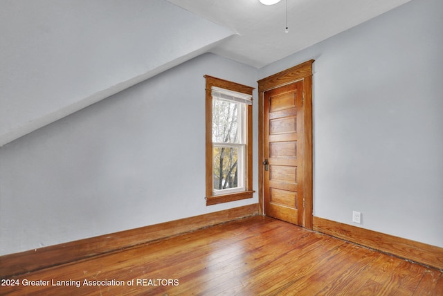 bonus room with wood-type flooring and vaulted ceiling