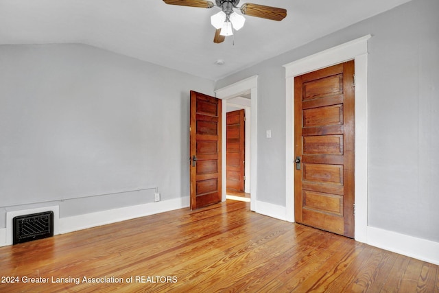 empty room featuring ceiling fan, lofted ceiling, and light hardwood / wood-style flooring