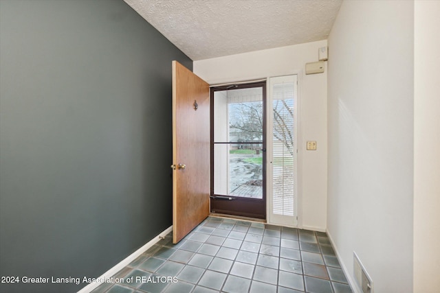 tiled entrance foyer featuring a textured ceiling