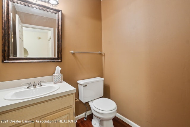 bathroom with wood-type flooring, vanity, and toilet