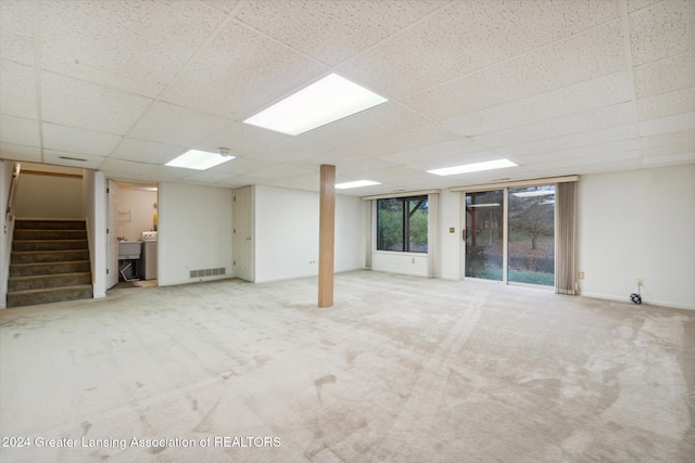 basement with a paneled ceiling, carpet floors, and sink