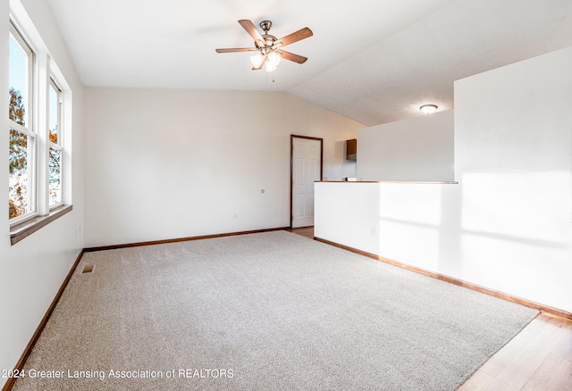 empty room featuring ceiling fan, light hardwood / wood-style floors, and vaulted ceiling