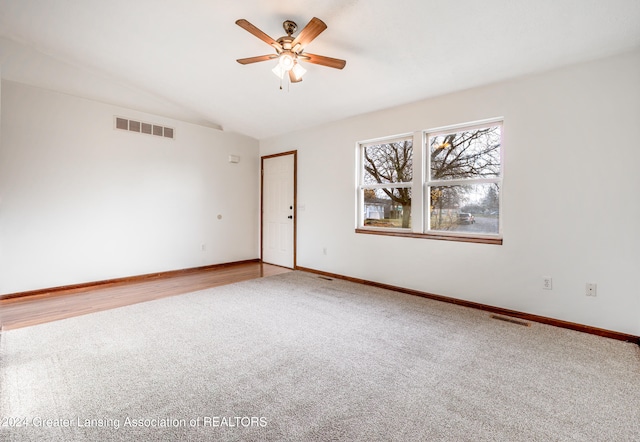 empty room featuring ceiling fan, carpet floors, and vaulted ceiling