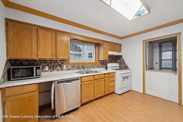 kitchen with sink, decorative backsplash, light wood-type flooring, ornamental molding, and appliances with stainless steel finishes