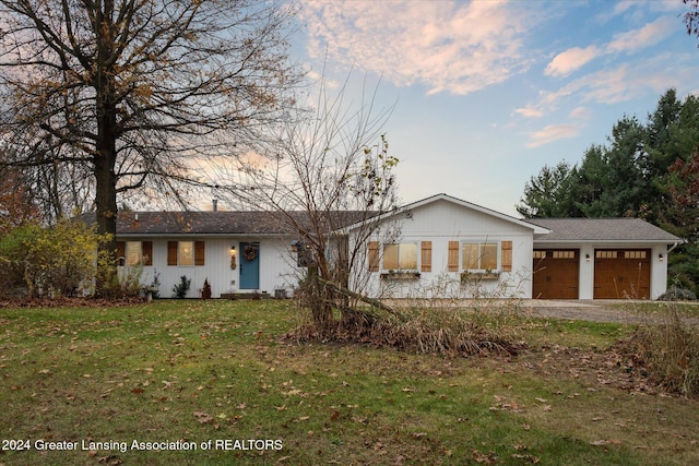 single story home featuring a garage and a front yard