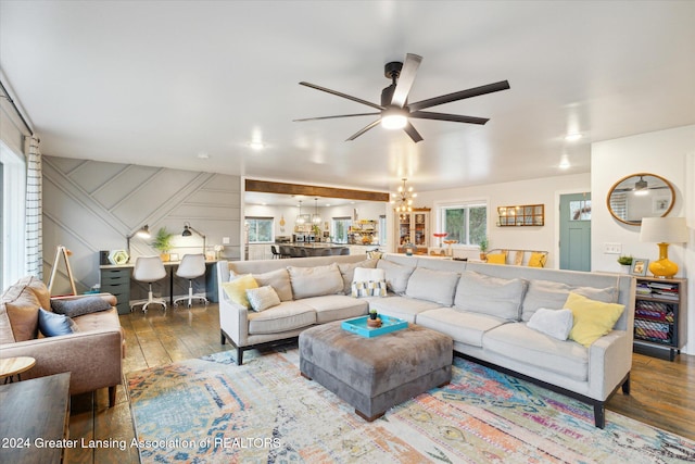 living room featuring wood-type flooring and ceiling fan with notable chandelier