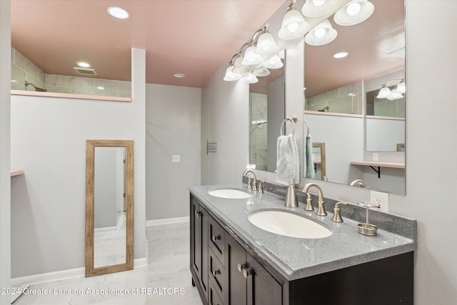 bathroom with a tile shower and vanity