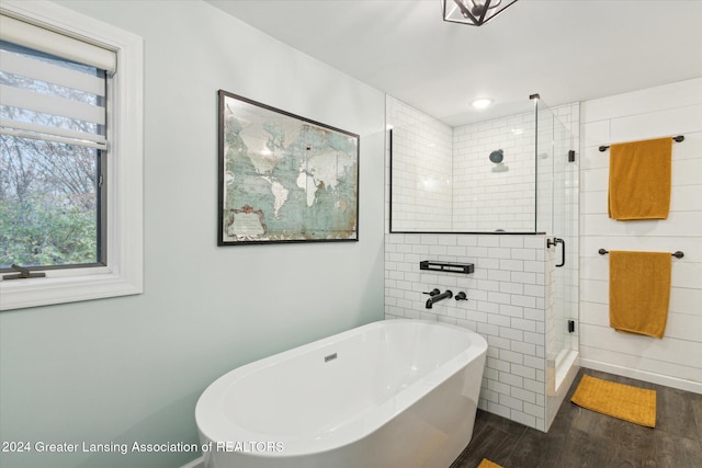 bathroom featuring hardwood / wood-style floors and plus walk in shower