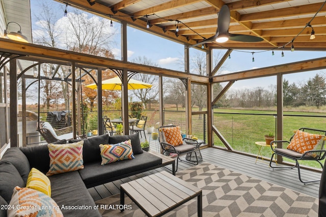 sunroom / solarium with vaulted ceiling with beams, ceiling fan, plenty of natural light, and wood ceiling