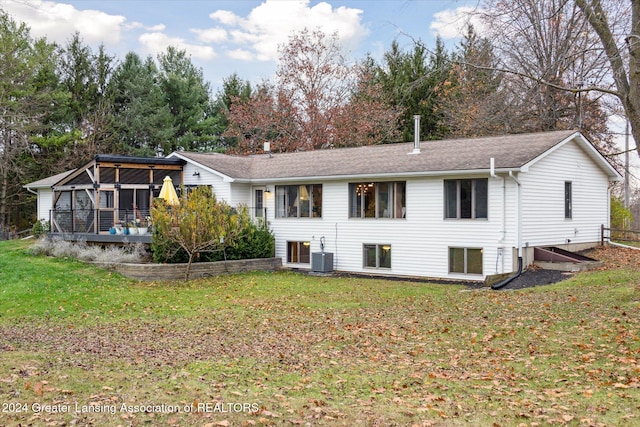 back of house with a lawn, a sunroom, central AC unit, and a wooden deck