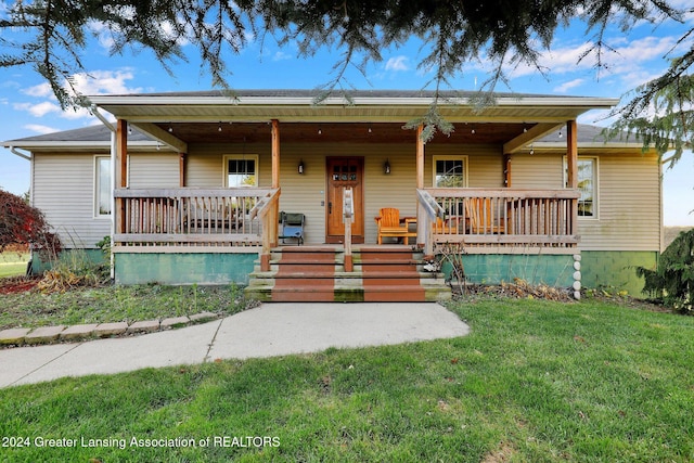 view of front of property featuring covered porch and a front lawn