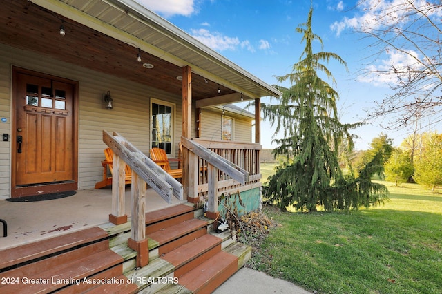 entrance to property with a yard and a porch