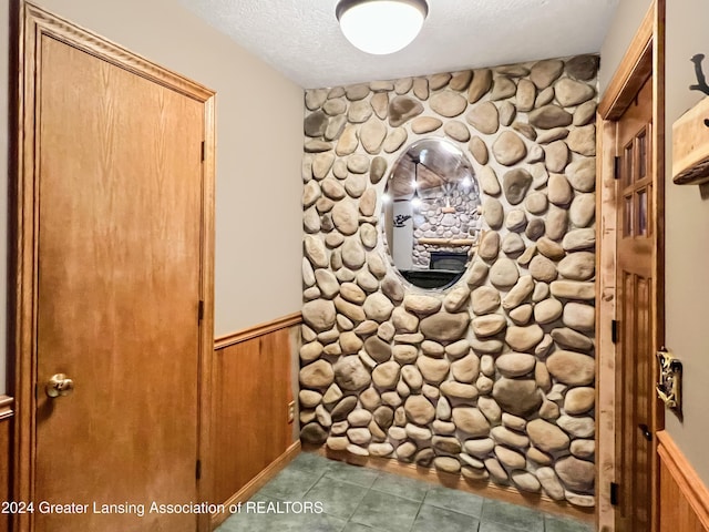 interior details with wood walls and a textured ceiling