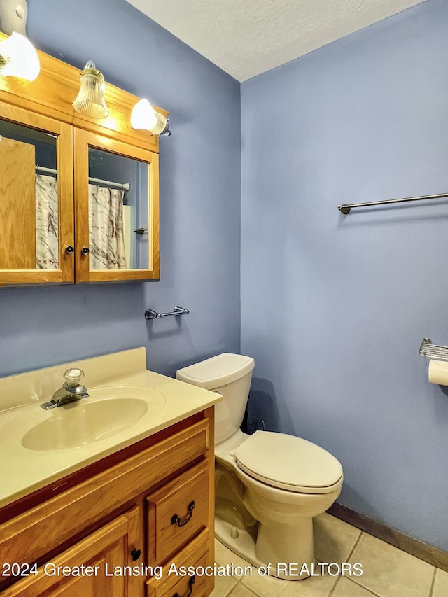 bathroom featuring toilet, a textured ceiling, vanity, and tile patterned floors