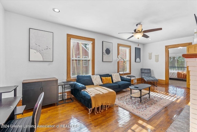 living room with a fireplace, light hardwood / wood-style floors, and ceiling fan