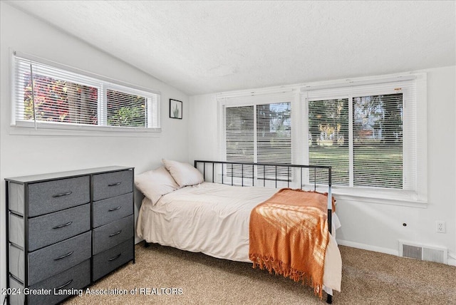 bedroom featuring light carpet, a textured ceiling, and vaulted ceiling