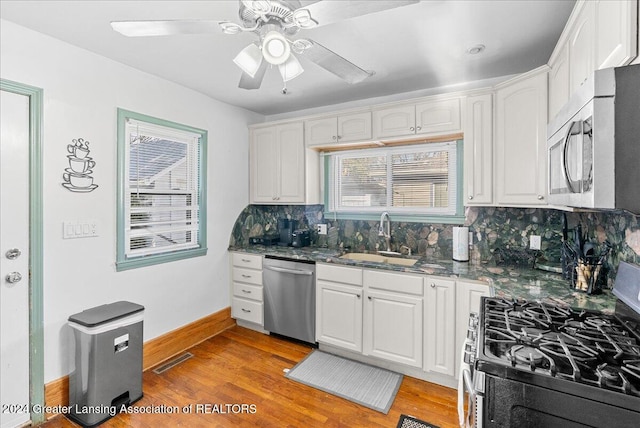 kitchen with decorative backsplash, sink, white cabinets, and stainless steel appliances