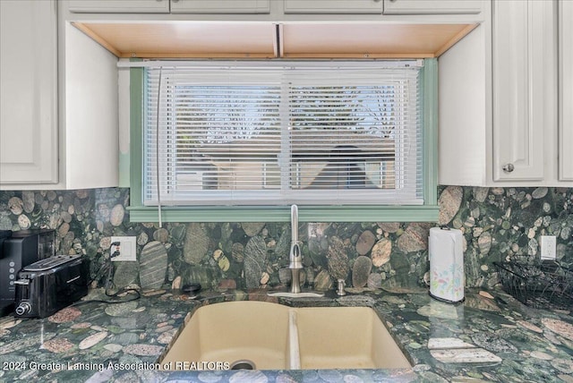 interior space with decorative backsplash, white cabinetry, plenty of natural light, and sink