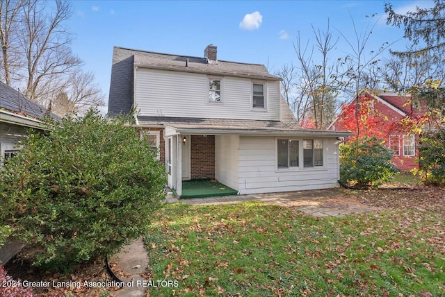 rear view of property featuring a patio and a lawn