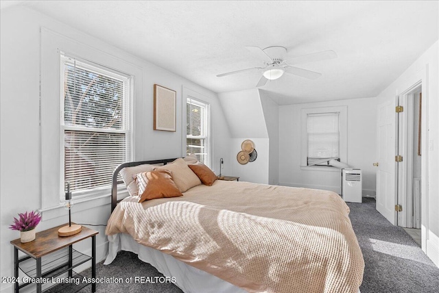 carpeted bedroom with ceiling fan, lofted ceiling, and multiple windows